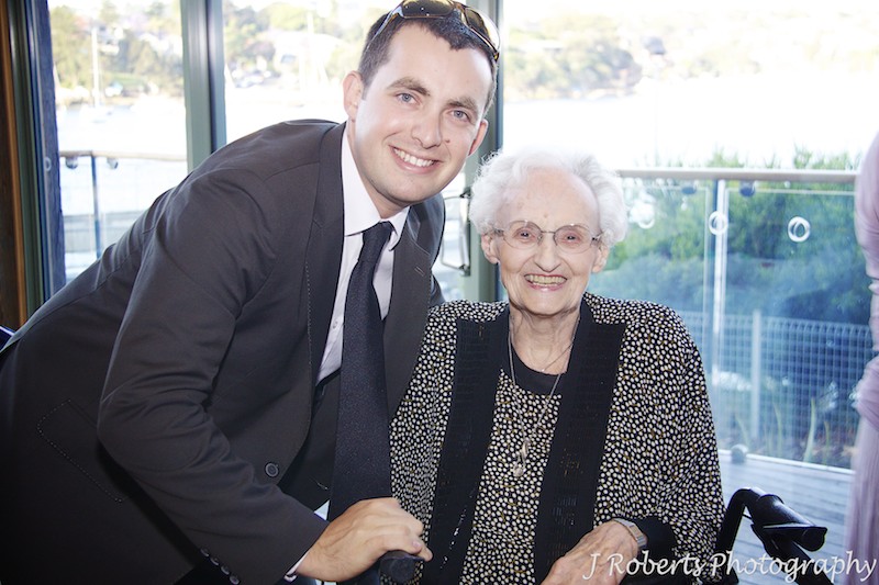 Groom smiling with grandmother at wedding reception - wedding photography sydney